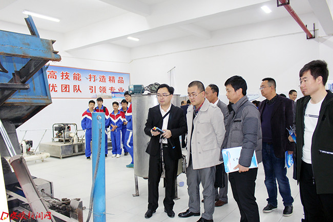 学校教师袁刚(左一)为裁判展示多功能 拖车.JPG