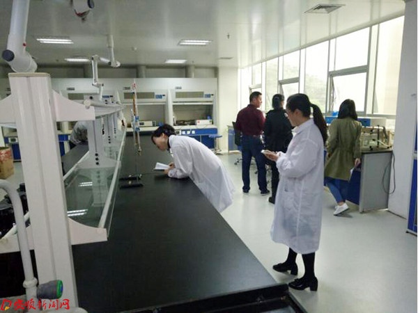 检查员在查看盐酸滴定管校验标识.jpg 检查员在查看盐酸滴定管校验标识.jpg