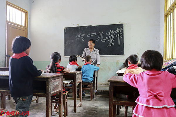 5月31日，在贵州省镇宁县良田乡纳亚村包包小学教学点，教师杨昌国在给学生们讲解六一儿童节由来。.jpg