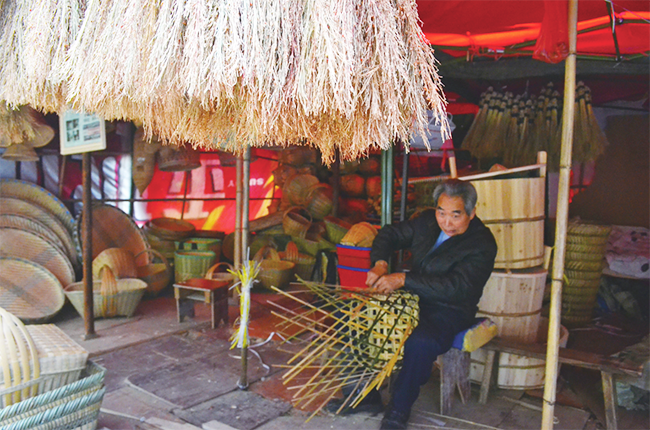 　　这些竹编匠人大多是上了年纪的老人，岁月虽在他们身上留下了沧桑的印记，但他们的手艺却越发的精湛。一双布满老茧的手灵敏而有力，一堆竹子、一些竹编材料……便组成了他们养家糊口的家当。图为竹编匠人