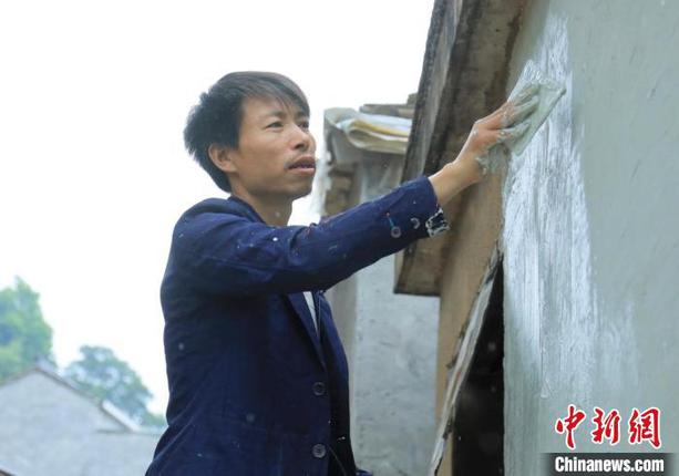 杨军昌为老房子刷墙 项菁 摄 杨军昌为老房子刷墙 项菁 摄