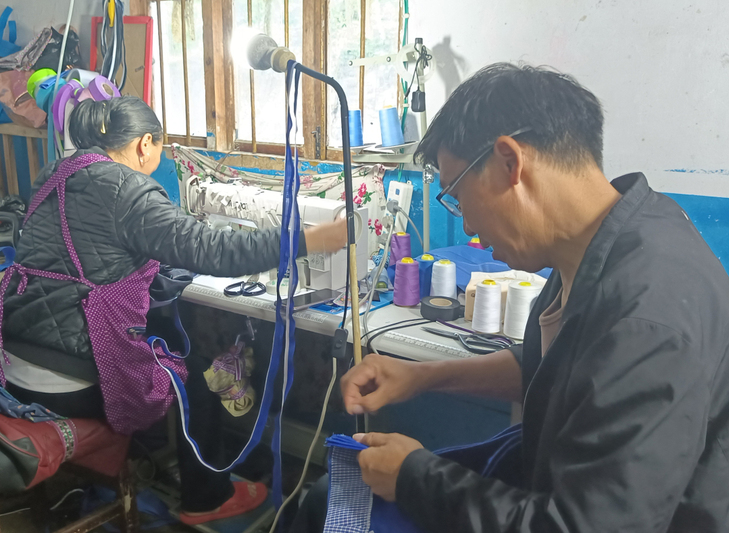韦周帮助妻子打理服饰上的线头.jpg