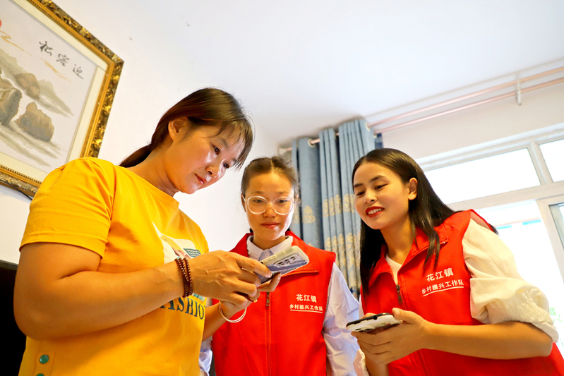 花江镇幸福社区干部陈玉兰（右）在社区群众家中推介“安心干”平台1.JPG