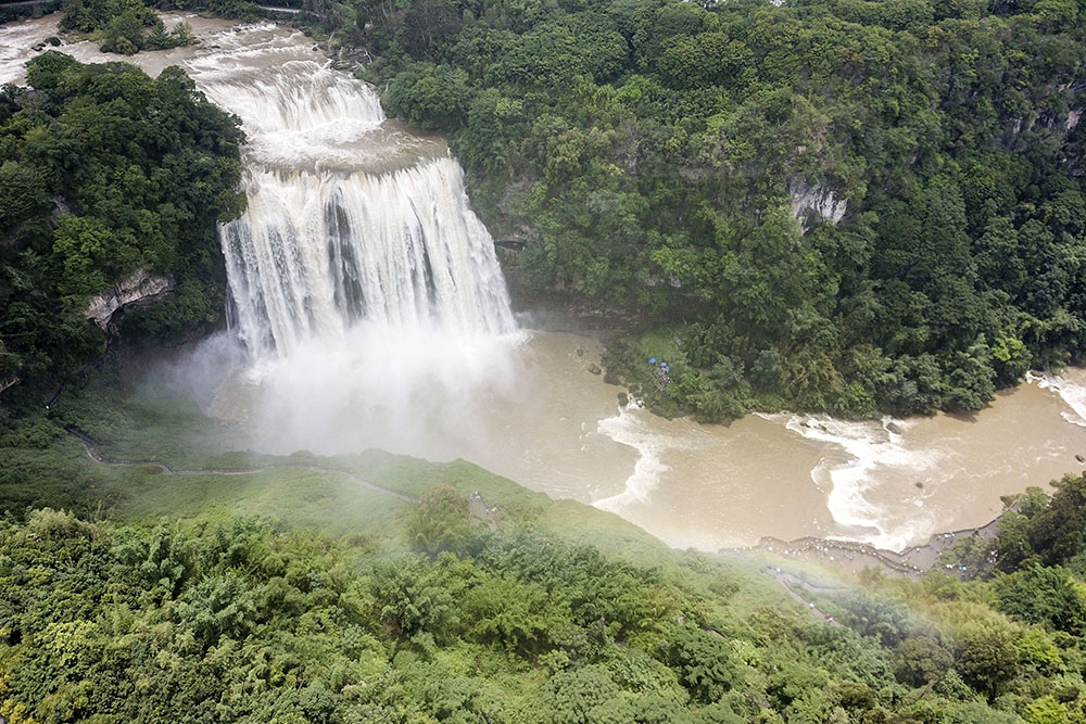 　　近日，受强降雨影响，黄果树瀑布进入丰水期，瀑布飞流直下,气势磅礴，壮观的瀑布吸引游客前来观赏。图为6月20日，游客在安顺黄果树瀑布前观赏。（安顺日报融媒体中心记者 卢维）