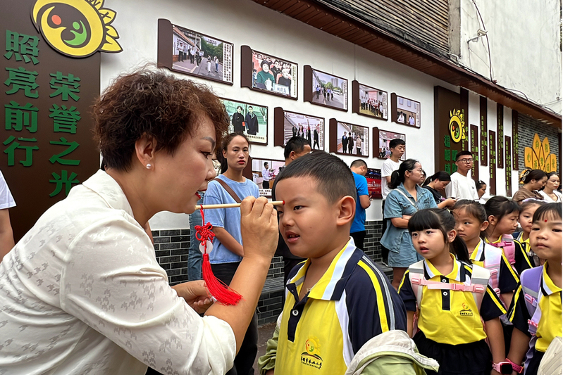 安顺市第五小学老师们为学生点上朱砂，开启学生们的智慧之门。.jpg